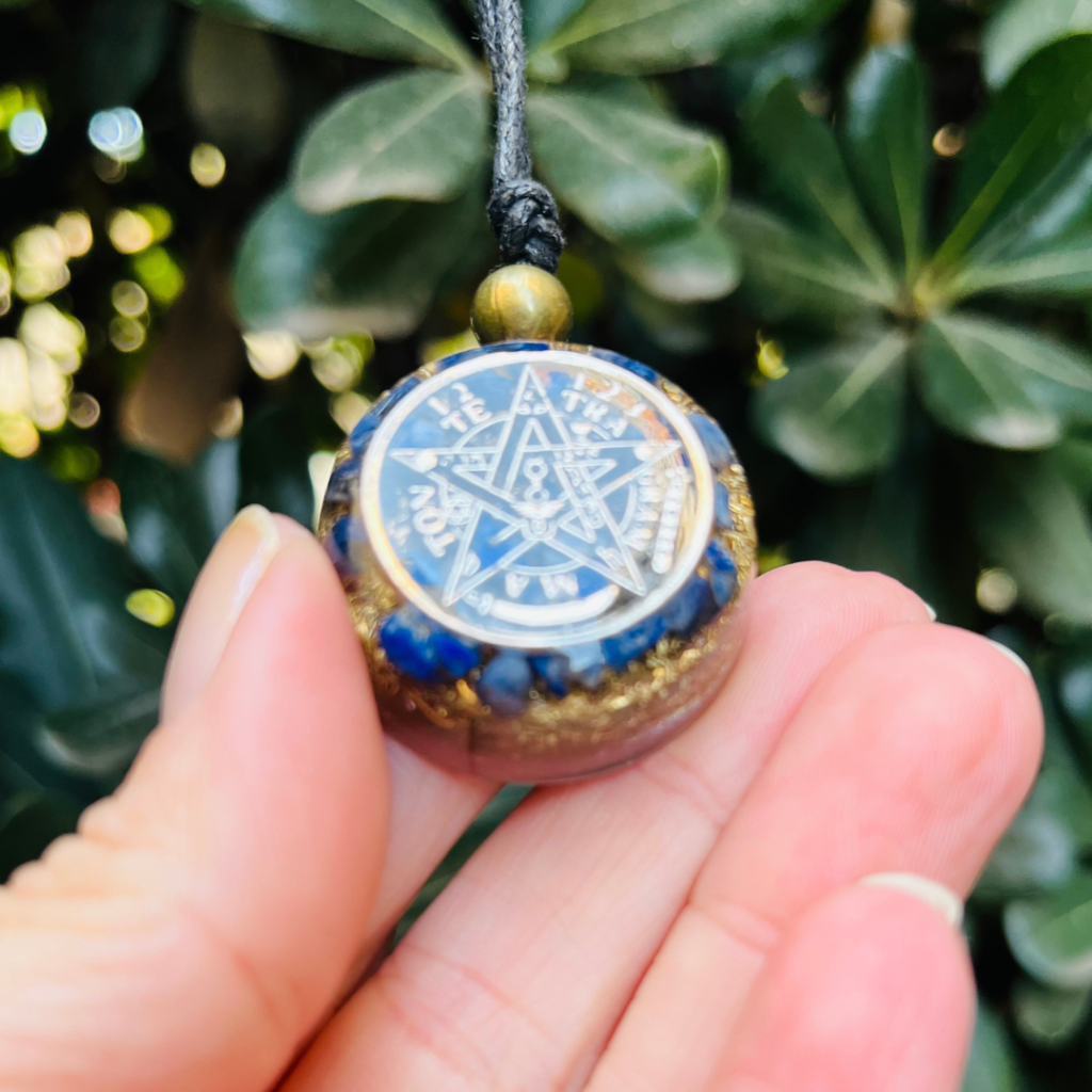 Amuleto de orgón con símbolo de pentagrama y cristales azules, protección y energía positiva.